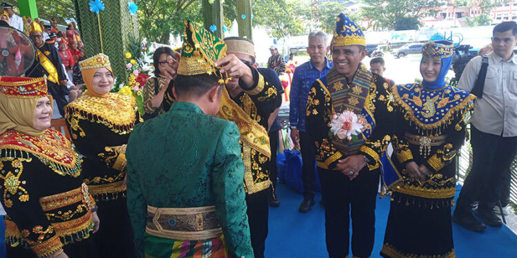 Pemasangan Siga Oleh Bupati ILHAM kepada Bupati bone pada peringatan HUT Ke-22 Touna, Kamis (18/12/2025).